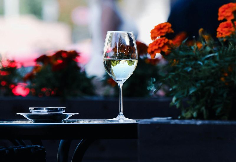 Glass of aromatic Gewurztraminer wine on a table with flowers