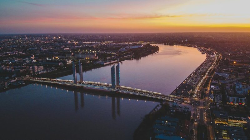 Stunning aerial view of Bordeaux modern bridge and city skyline at sunset over the Garonne River