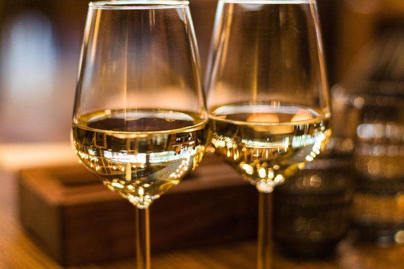 Two elegant glasses of golden white wine, similar to Sauternes dessert wine