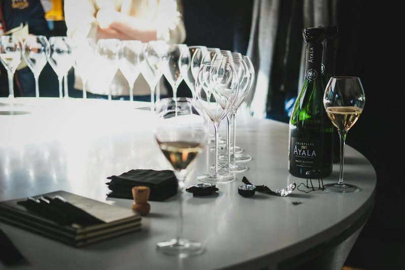 Champagne glasses and a bottle arranged on a table at a grower tasting in Aÿ-Champagne, France