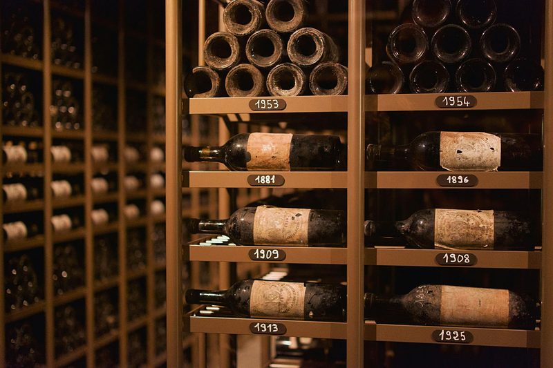 Vintage champagne and wine bottles stored in an old French cellar, covered in dust from years of aging