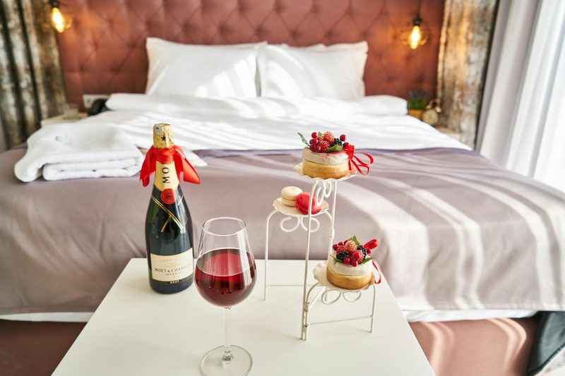 An elegant bedroom setting with champagne, a wine glass, and desserts creating a luxurious atmosphere