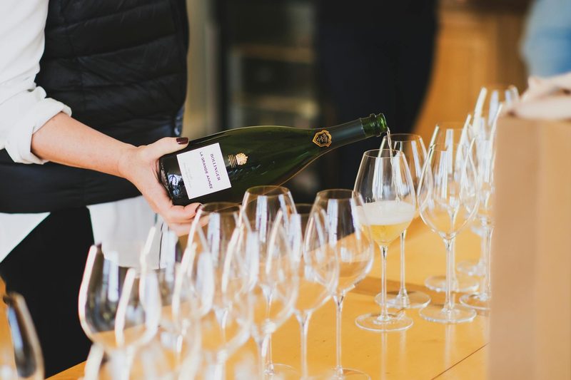 A person pouring champagne into glasses at a tasting session in Aÿ-Champagne, France