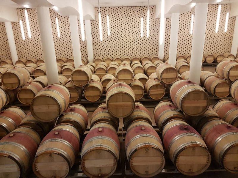 Wooden wine barrels stored in a French wine cellar