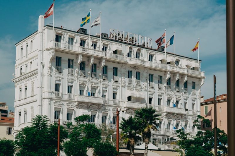 Elegant facade of a hotel in southern France with vibrant flags